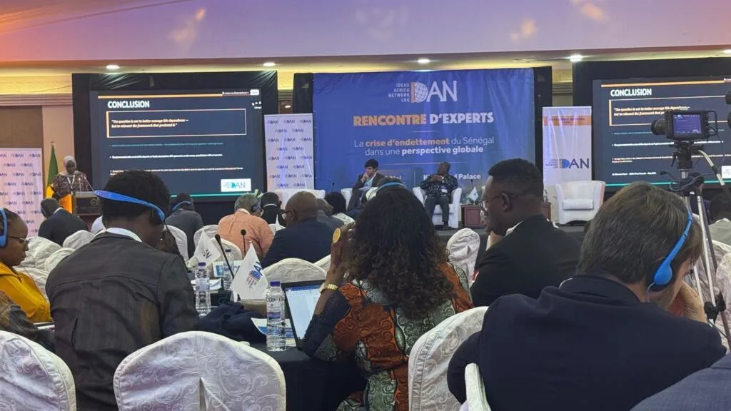Événement économique à Dakar avec des experts discutant de la dette