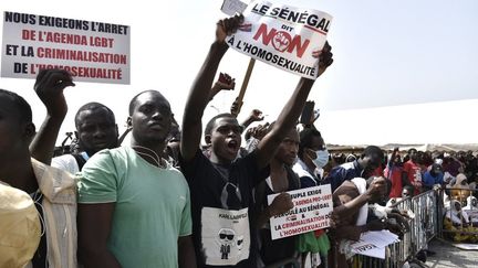 Des manifestants brandissant des pancartes lors d'une manifestation le 20 février 2022 sur la place de l'Obélisque à Dakar, réclamant un durcissement de la répression contre l'homosexualité.