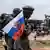 Des Centrafricains devant une statue représentant des mercenaires de Wagner