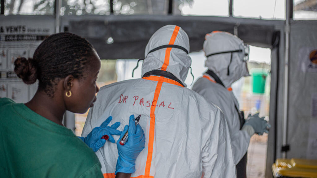 Agent d'hygiène préparant l'équipement de protection d'un médecin avant son intervention dans un centre de traitement Ebola à Bunia, en Ituri