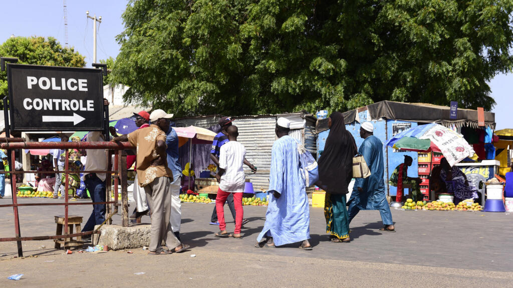 À Karang, au Sénégal, en mai 2016, des voyageurs franchissent un poste de contrôle de police pour se rendre en Gambie.