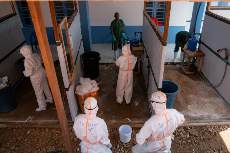 Soignants en combinaison de protection au chevet d'un patient atteint d'Ebola en RDC